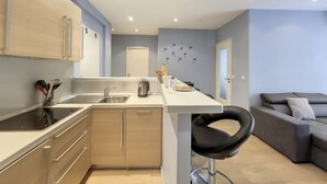 A modern kitchen with a central island, a dining area with a sofa, and a kitchenette. - N&J - RIVIERA PROVENCE - CENTRAL - NEAR SEA (Niza)