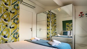 Une chambre d ’hôtel avec un lit, un miroir et une armoire.