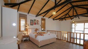 A bedroom with a wooden ceiling, a bed with white bedding, a nightstand, a lamp, and a window with blinds. - Green Garden House Hotel&Spa (Tefenni)