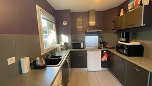A compact kitchen with a microwave, toaster, and coffee maker. - Garden-Level Apartment 100m from Beach with Parking & Terrace (Capbreton)