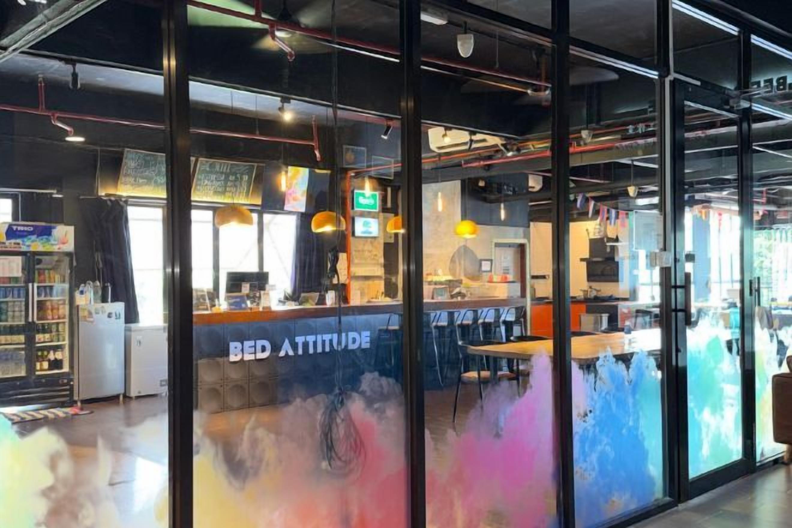 A modern interior with a bar area, glass walls, and a visible ceiling with exposed pipes.