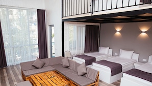A modern hotel room with a balcony, a sofa, two beds, and a wooden coffee table. - Libereco (Batumi)