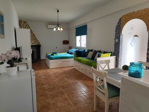 A compact living space with a kitchenette, a dining area, and a sofa set.