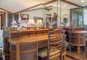 A room with a large mirror, wooden furniture, and a ceiling fan. - Captivating Tropical Escape at Wailea Elua 2202 - Breathtaking Ocean Views (Wailea, Maui)