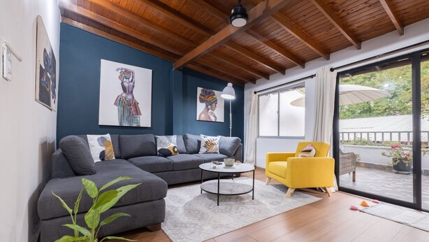 A modern living room with a gray sofa, a yellow armchair, and a round coffee table. - Light-filled Envigado, top-floor w/ Large Patio (Envigado)