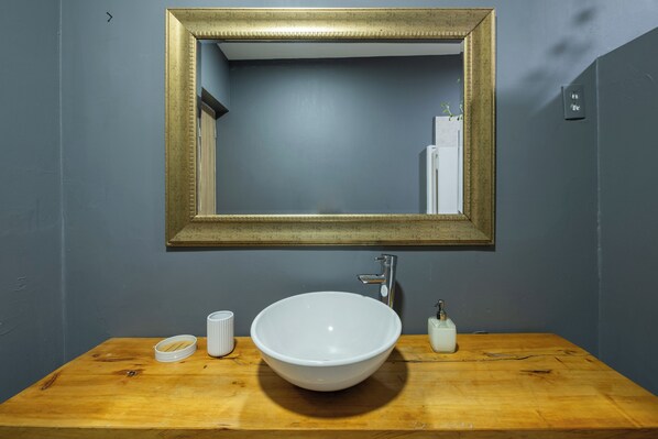 A bathroom with a wooden vanity, a white sink, and a gold-framed mirror. - Light filled, Envigado flat! Over 2000 square feet (Envigado)