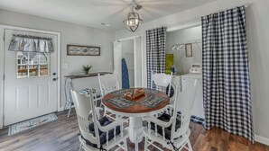A dining area with a round wooden table, white chairs, and a chandelier. - Location! Location!<br>Minutes to all shopping and your favorites restaurant!  (Cullman)