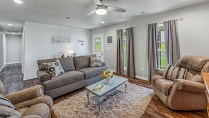 A modern living room with a grey sofa, a recliner, a coffee table, and a ceiling fan. - Location! Location!<br>Minutes to all shopping and your favorites restaurant!  (Cullman)