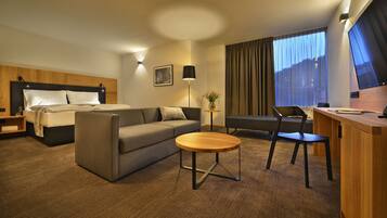Een hotelkamer met een bed, een bank, een bureau en een stoel.