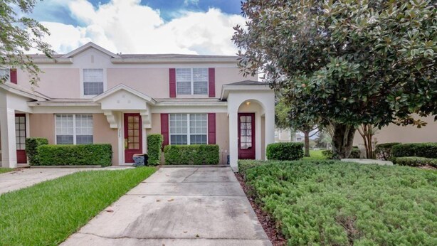 A two-story residential building with a symmetrical facade, a central entrance, and a well-maintained lawn. - Windsor_palms_2323n (Kissimmee)
