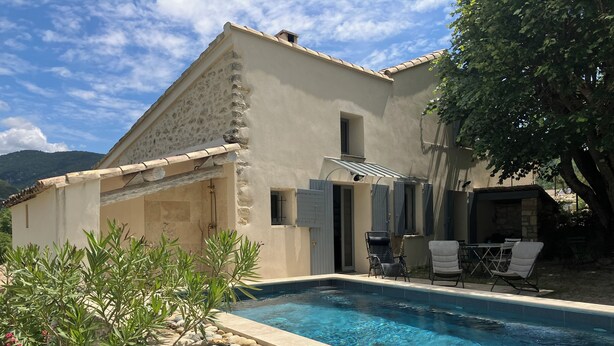 A poolside area with a stone wall, a pool, and outdoor furniture. - Provencal farmhouse with pool at the foot of Mont-Ventoux (Malaucène)