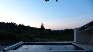 A rectangular outdoor water feature with a stone border, surrounded by a paved area. - Provencal farmhouse with pool at the foot of Mont-Ventoux (Malaucène)