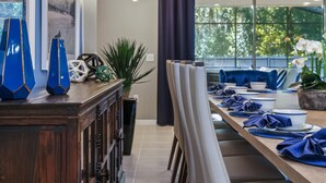 Un comedor moderno con una larga mesa de madera, sillas y una lámpara original.