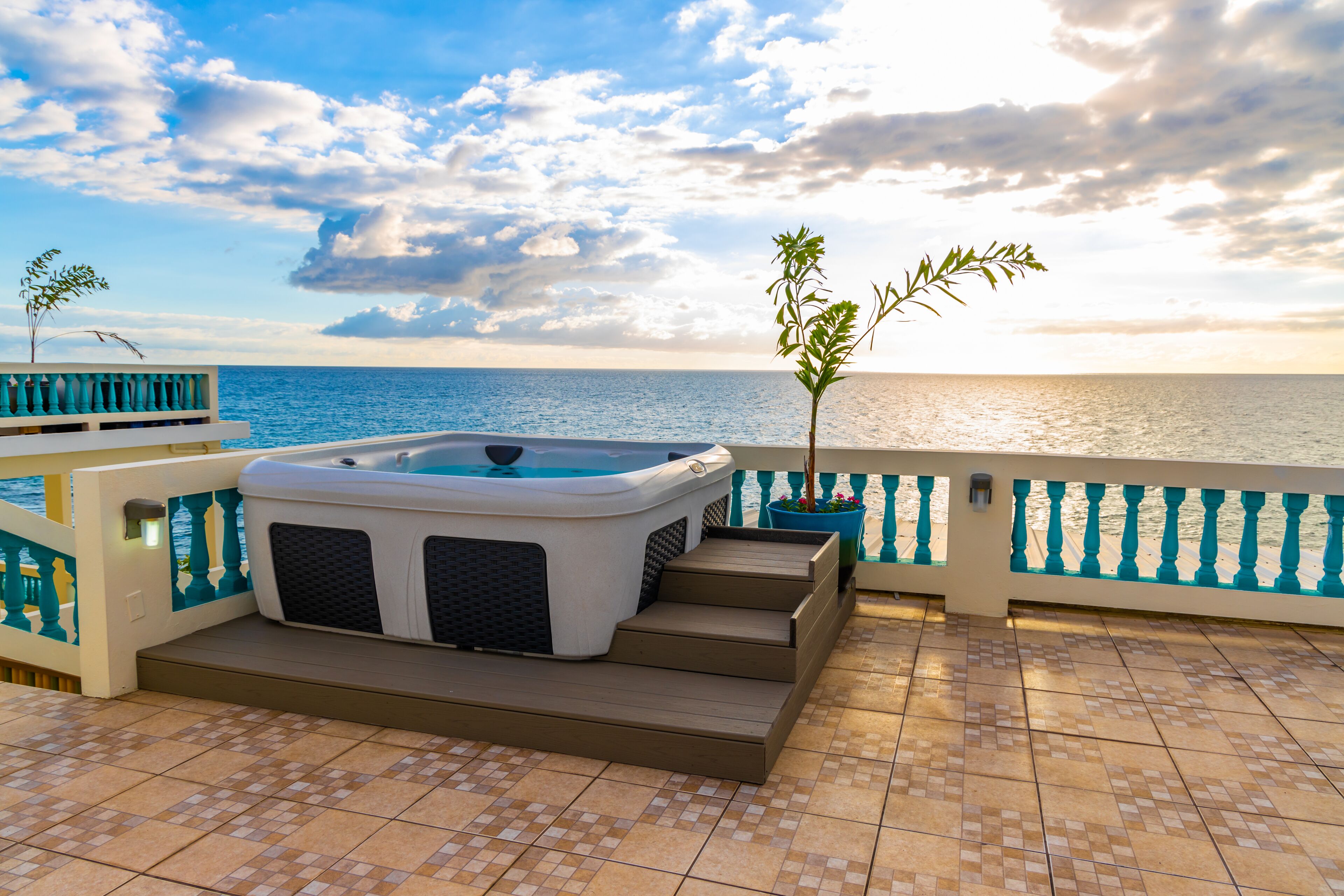 A hot tub on a balcony with a view of the sea.