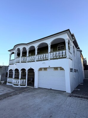 A two-story building with a balcony, a garage, and a symmetrical facade. - Relax and enjoy in this beautiful home in a quiet neighbourhood. (Mineral Hieghts)