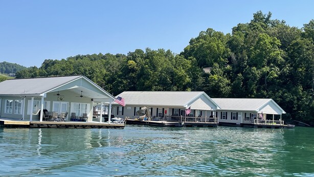Een pand aan het water met een overdekte steiger, meerdere hutten en een Amerikaanse vlag.