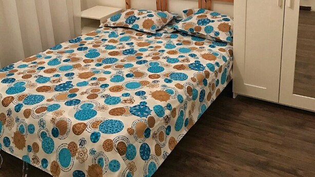 Makuuhuone, jossa on sänky, vaatekaappi ja yöpöytä.