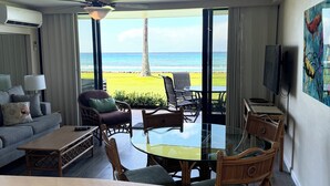 Een hotelkamer met balkon, een bank, een tafel en stoelen.