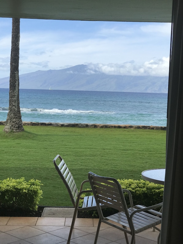 A patio with a view of the ocean and mountains.