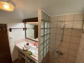 Ein Badezimmer mit Waschbecken, Spiegel und Dusche.