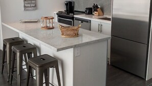 A modern kitchen with a central island, stainless steel appliances, and a minimalist design.