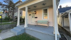 A two-story house with a porch, a bench, and a mailbox. - Historical Louisiana Style Home (Dayton)