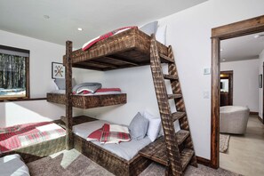A bunk bed with a ladder, a gray sofa, and a framed picture on the wall. - Big Sky Vacation Rentals: MVC Spotted Eagle (Big Sky)