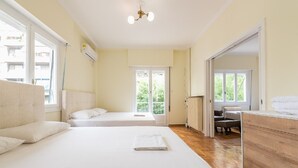 Une chambre d’hôtel avec deux lits, une commode en bois et une vue sur l’extérieur.