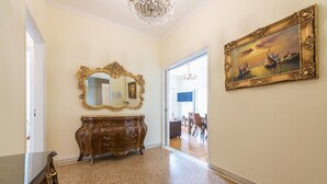 Un couloir avec une commode en bois, un grand miroir et un tableau encadré accroché au mur.