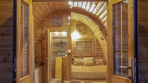 Un intérieur en bois comprenant un espace de vie chaleureux, une cuisine et une salle de bain.