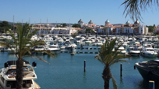 A marina with numerous boats docked, surrounded by buildings with distinctive architecture. - CASA JOY Vilamoura Apartment (Vilamoura)