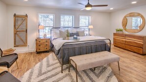 A bedroom with a bed, bedside tables, a bench, a dresser, a mirror, and a ceiling fan. - #AzStoneCabin- Finest Luxury Cabin In Pinetop- Lakeside! (Pinetop)
