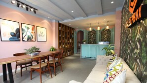 A modern interior with a dining area, a sofa, and a kitchen. - Sleepbox Hostel Phu Quoc (Phu Quoc)