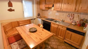 Une cuisine de taille réduite, avec des meubles de rangement en bois, une cuisinière et un évier.
