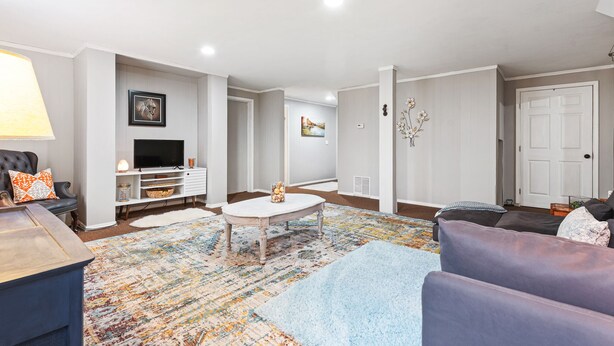 Un salon moderne avec un canapé, une table basse et un téléviseur.