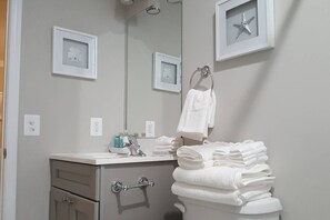 Een bad/douchecombinatie, een haardroger, handdoeken, zeep