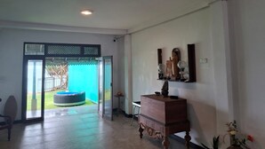 A room with a wooden cabinet, a small table, and a decorative mirror on the wall.