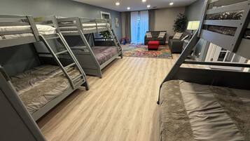 Ett studentrum med våningssängar, en soffa, ett litet bord och en växt.
