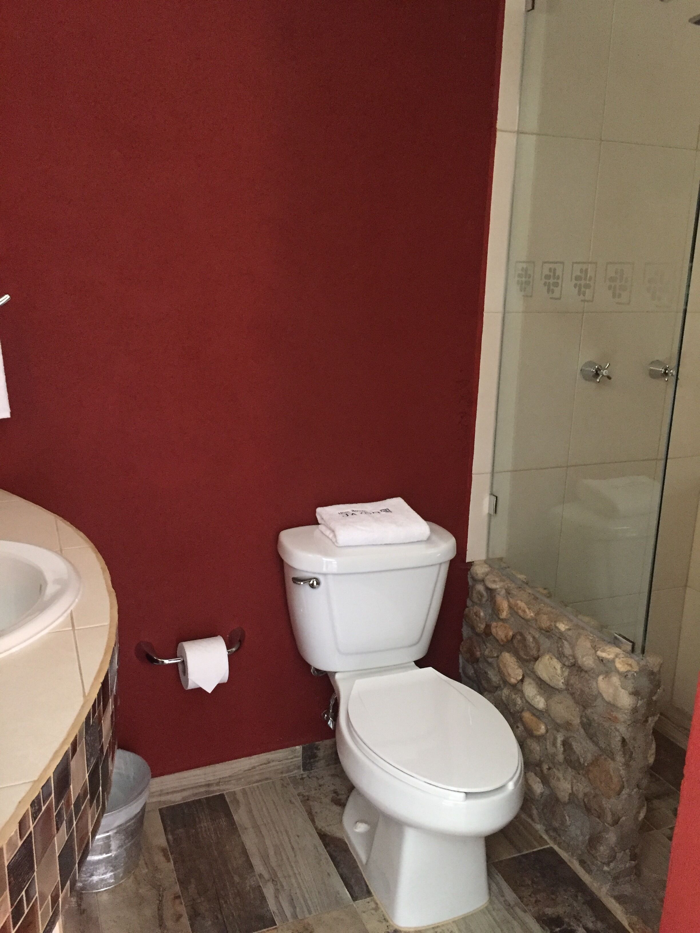 Un baño con inodoro, lavamanos y zona de ducha.