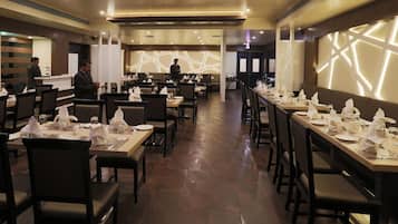 A restaurant with multiple dining tables, chairs, and a counter area.