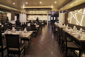 A restaurant with multiple dining tables, chairs, and a counter area.