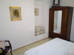 A bedroom with a bed, a dresser, a mirror, and a framed picture on the wall. - Not just relax holidays (Lucoli AQ)