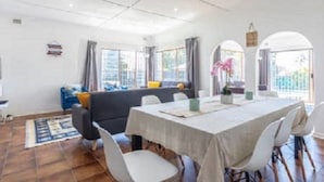 A dining area with a table, chairs, and a sofa.