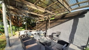 An outdoor patio with wicker furniture, a table, and chairs.
