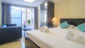 Een hotelkamer met een bed, een bureau, een stoel, een lamp en uitzicht op het buiten.