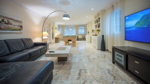 Een moderne woonkamer met een bank, een salontafel, een pooltafel en een televisie.