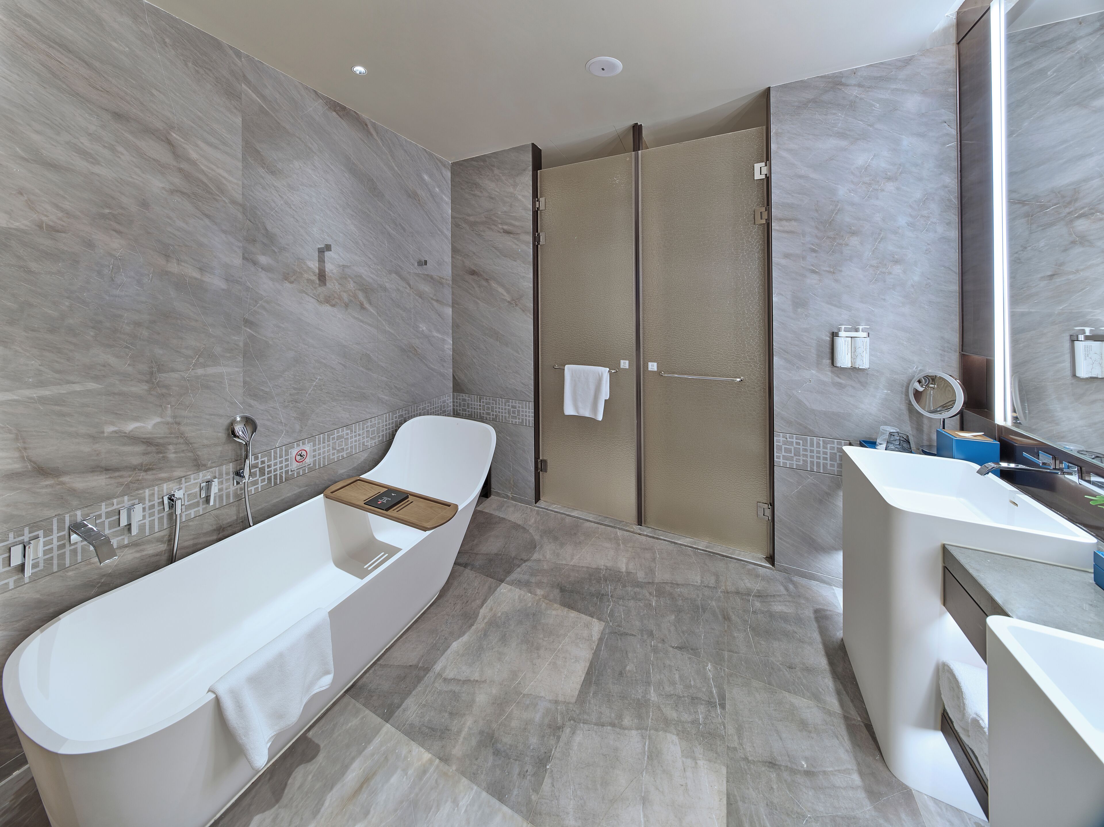 A modern bathroom with a freestanding bathtub, a walk-in shower, and a vanity with a mirror.