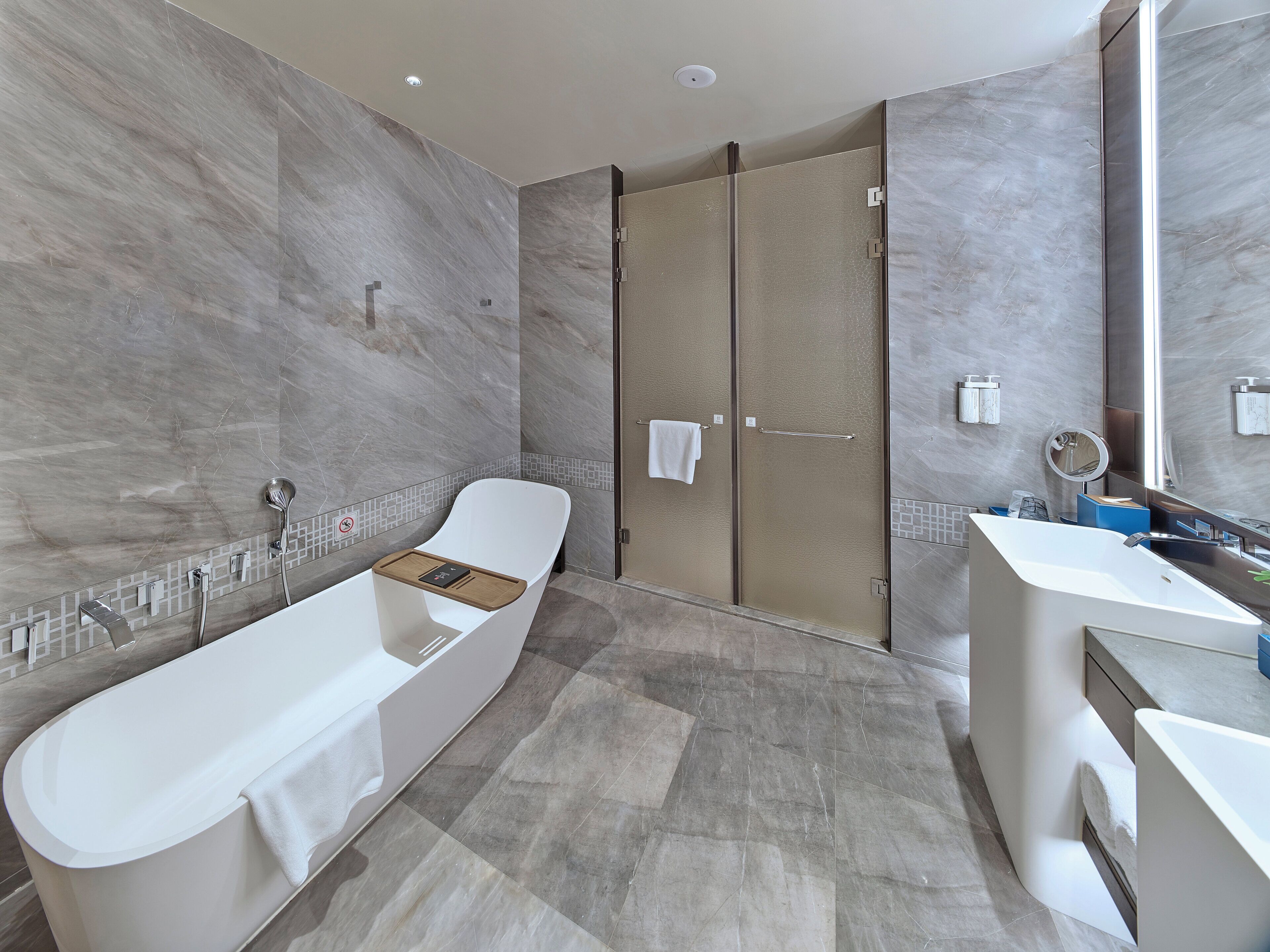 Un baño moderno con una bañera independiente, cabina de ducha y tocador con espejo.