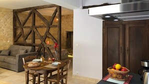 Zona de menjador acollidora amb taula de fusta, cadires i un separador rústic de fusta.