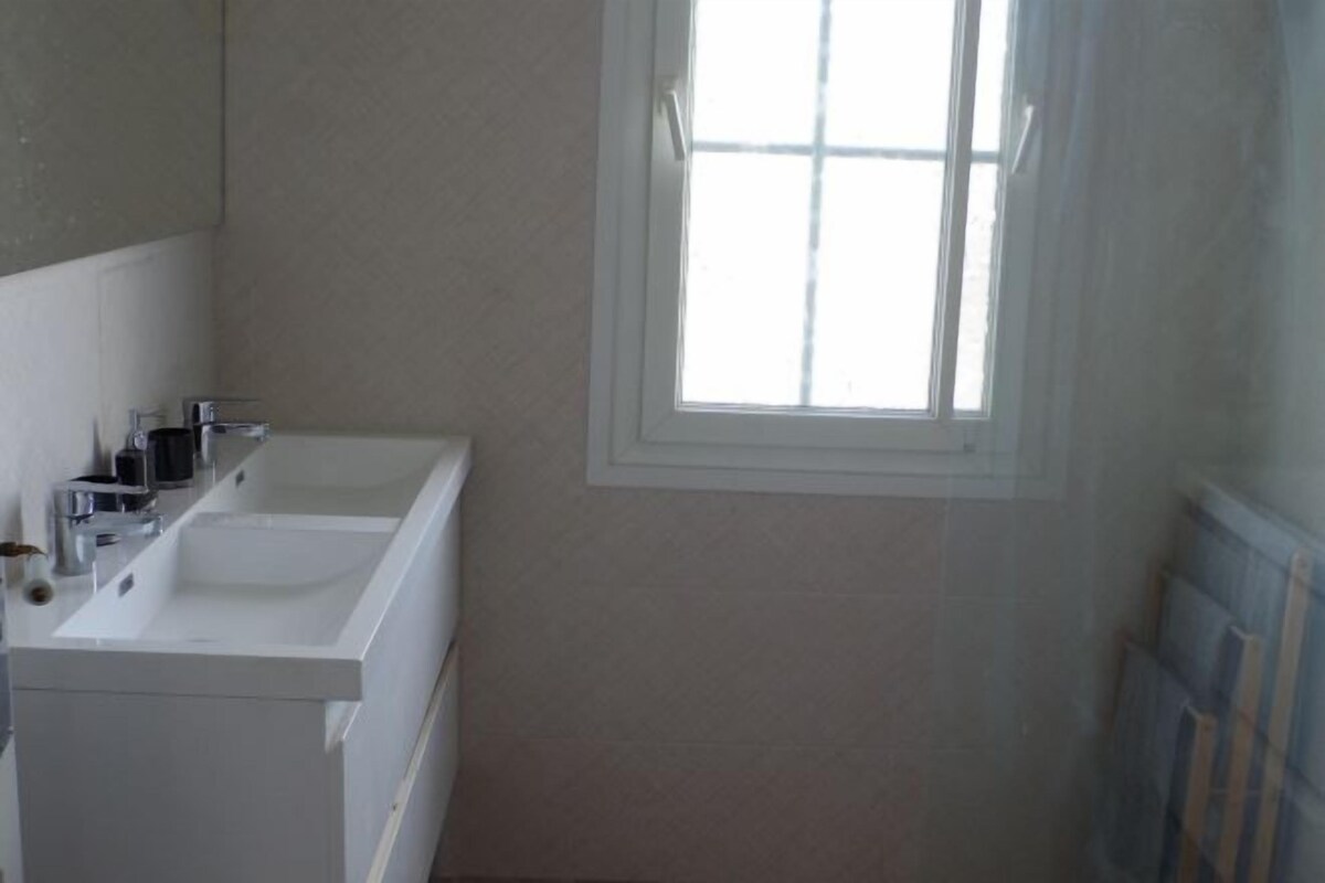 A bathroom with two sinks, a mirror, and a window.